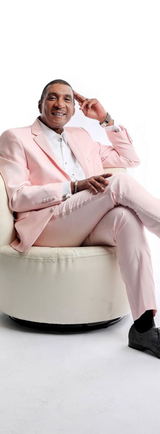 Kevan Peabody in a pink suit, seated in a white chair